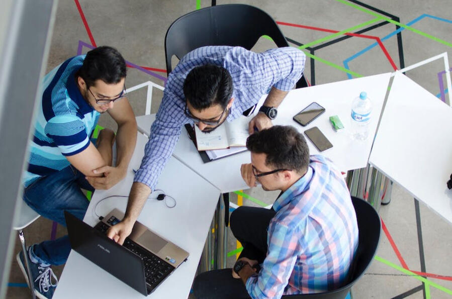 Three engineers discussing project at computer